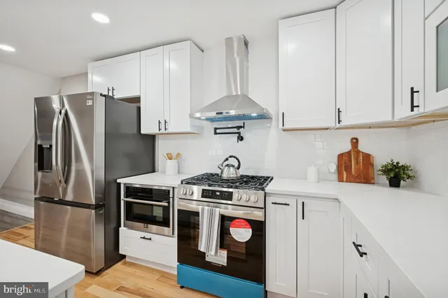 a kitchen with stainless steel appliances a stove a refrigerator and a cabinets