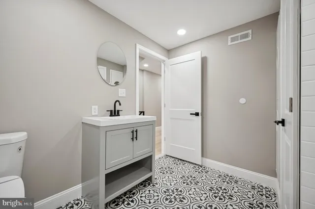 a bathroom with a sink a toilet and a mirror