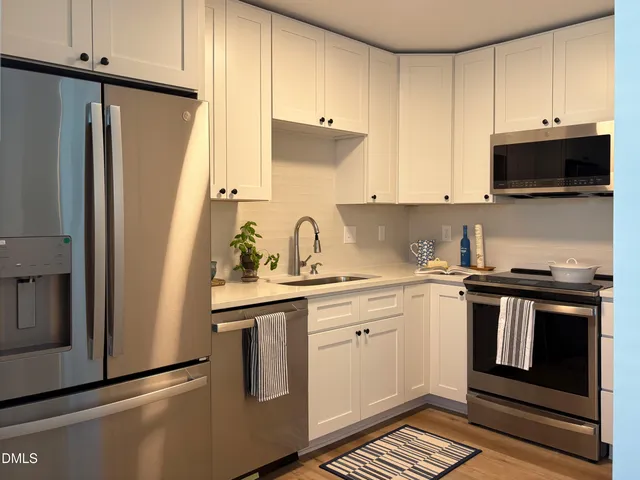 a kitchen with stainless steel appliances a stove a sink and a refrigerator