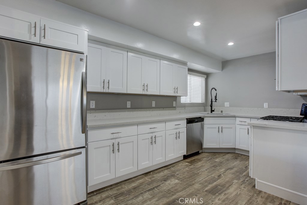 a kitchen with granite countertop white cabinets and refrigerator