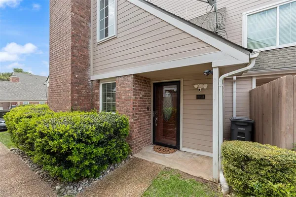 a view of a house with brick walls and a yard