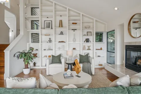 a living room with furniture a fireplace and a large window