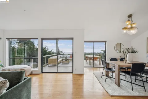 a balcony with wooden floor table and chairs