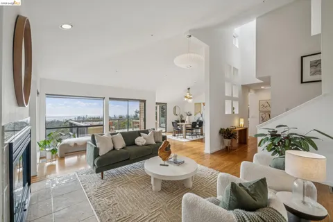a living room with furniture a fireplace and a large window