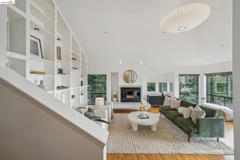a living room with furniture fireplace and a large window