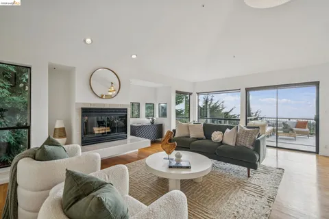 a living room with furniture a fireplace and a large window