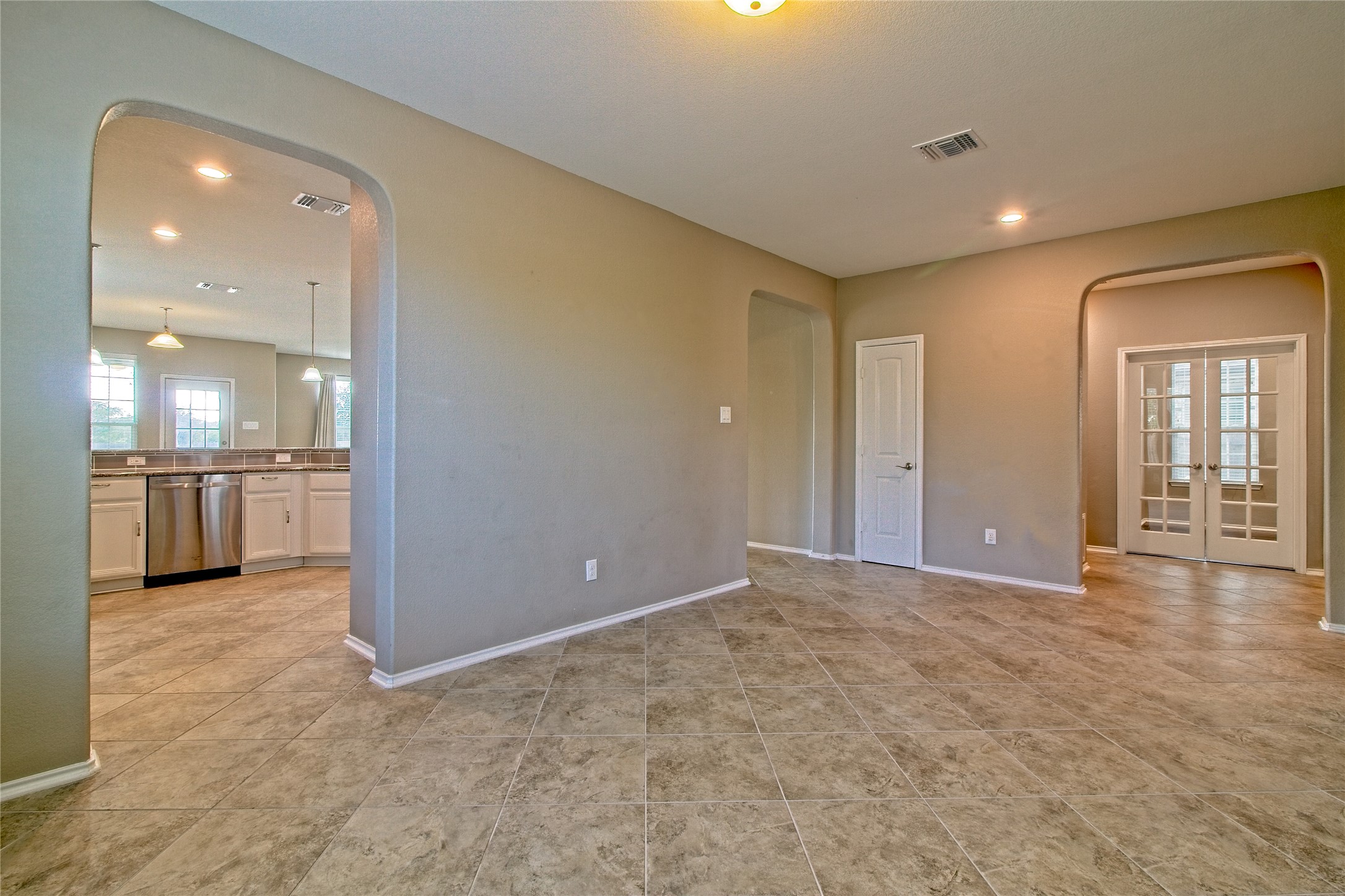 31443 Kingsway Road Georgetown, TX 78628 - Photo 6 of 40 Arched doorways and a seamless flow define this inviting interior, leading to a modern kitchen.