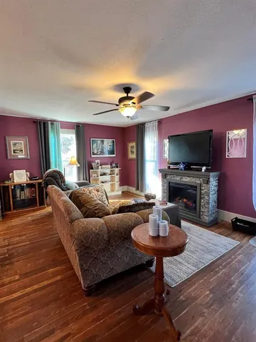 a living room with furniture a fireplace and a flat screen tv