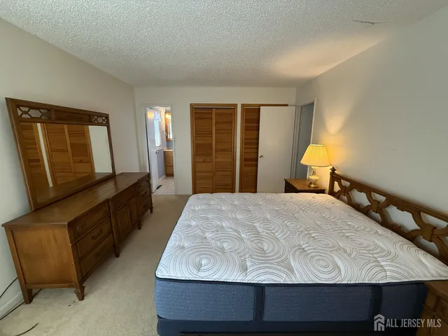 a bedroom with a bed window and dresser