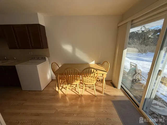 a view of a dining room with furniture wooden floor and a kitchen