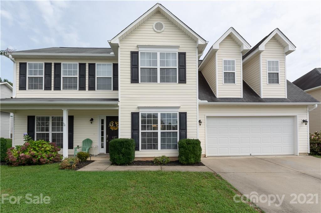 127 Yadkin Road Fletcher, NC 28732 - Photo 1 of 25 a front view of a house with a yard and garage