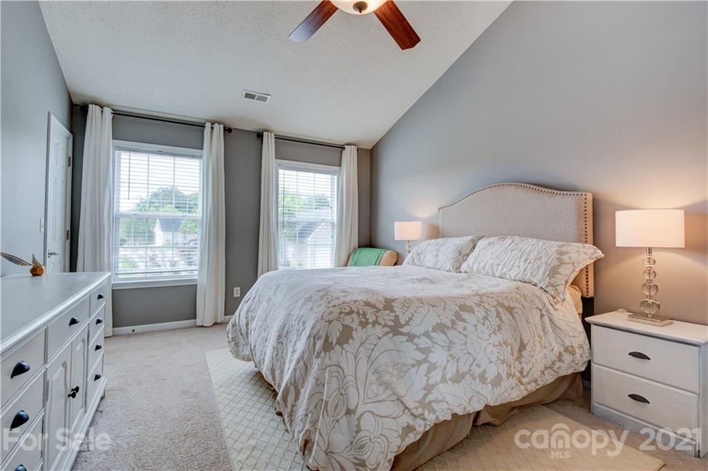 127 Yadkin Road Fletcher, NC 28732 - Photo 13 of 25 a spacious bedroom with a bed and a lamp on dresser