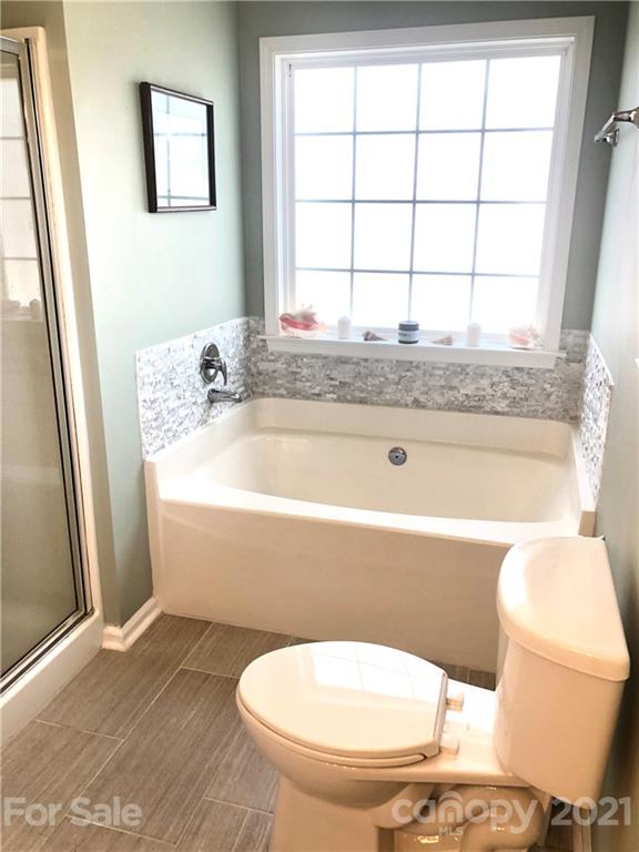 127 Yadkin Road Fletcher, NC 28732 - Photo 15 of 25 a bathroom with a granite countertop toilet a sink and a window