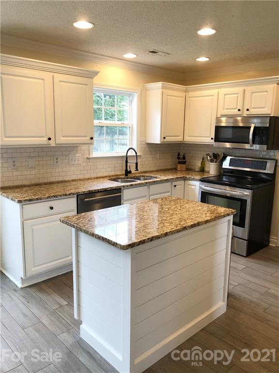 127 Yadkin Road Fletcher, NC 28732 - Photo 6 of 25 a kitchen with stainless steel appliances granite countertop a sink stove and cabinets