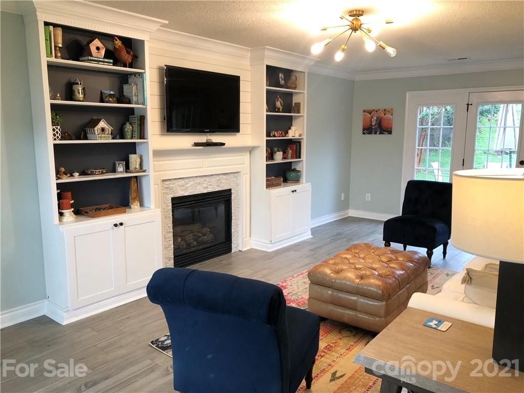 127 Yadkin Road Fletcher, NC 28732 - Photo 9 of 25 a living room with furniture a flat screen tv and a fireplace