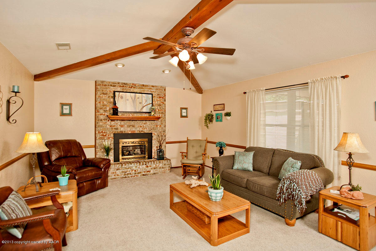 5713 South Milam Street Amarillo, TX 79110 - Photo 3 of 22 a living room with furniture a fireplace and a flat screen tv