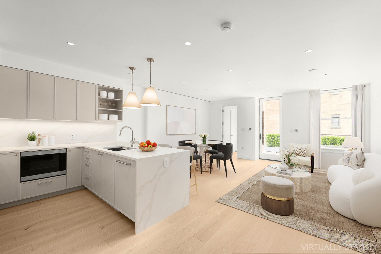 a view of living room kitchen with stove and white cabinets