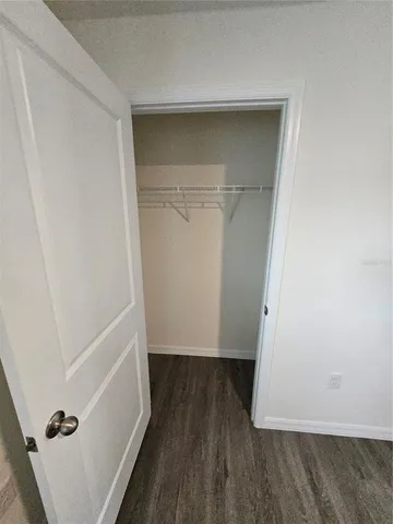 a view of walk in closet with wooden floor