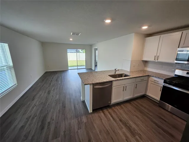 a kitchen with a sink window and cabinets
