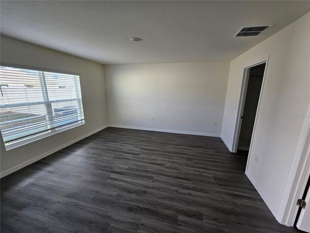 2636 Hardin Way Zephyrhills, FL 33541 - Photo 7 of 42 an empty room with wooden floor and windows