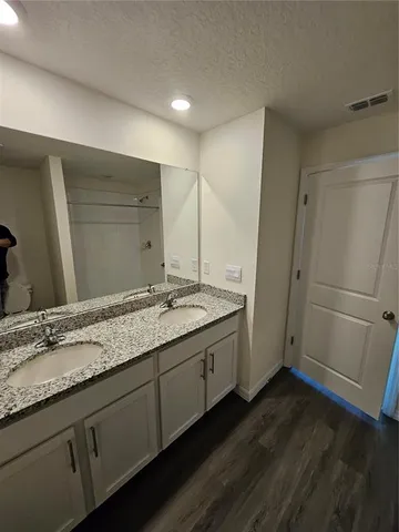 a bathroom with a granite countertop sink and a mirror