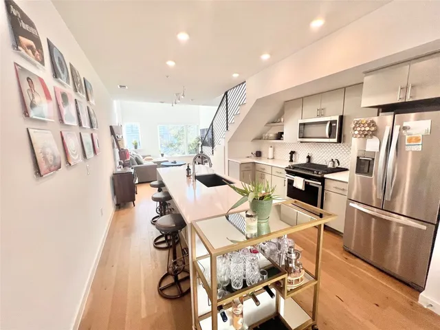 a kitchen with stainless steel appliances granite countertop a refrigerator and a stove top oven