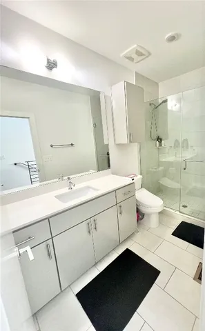 a bathroom with a double vanity sink mirror and toilet