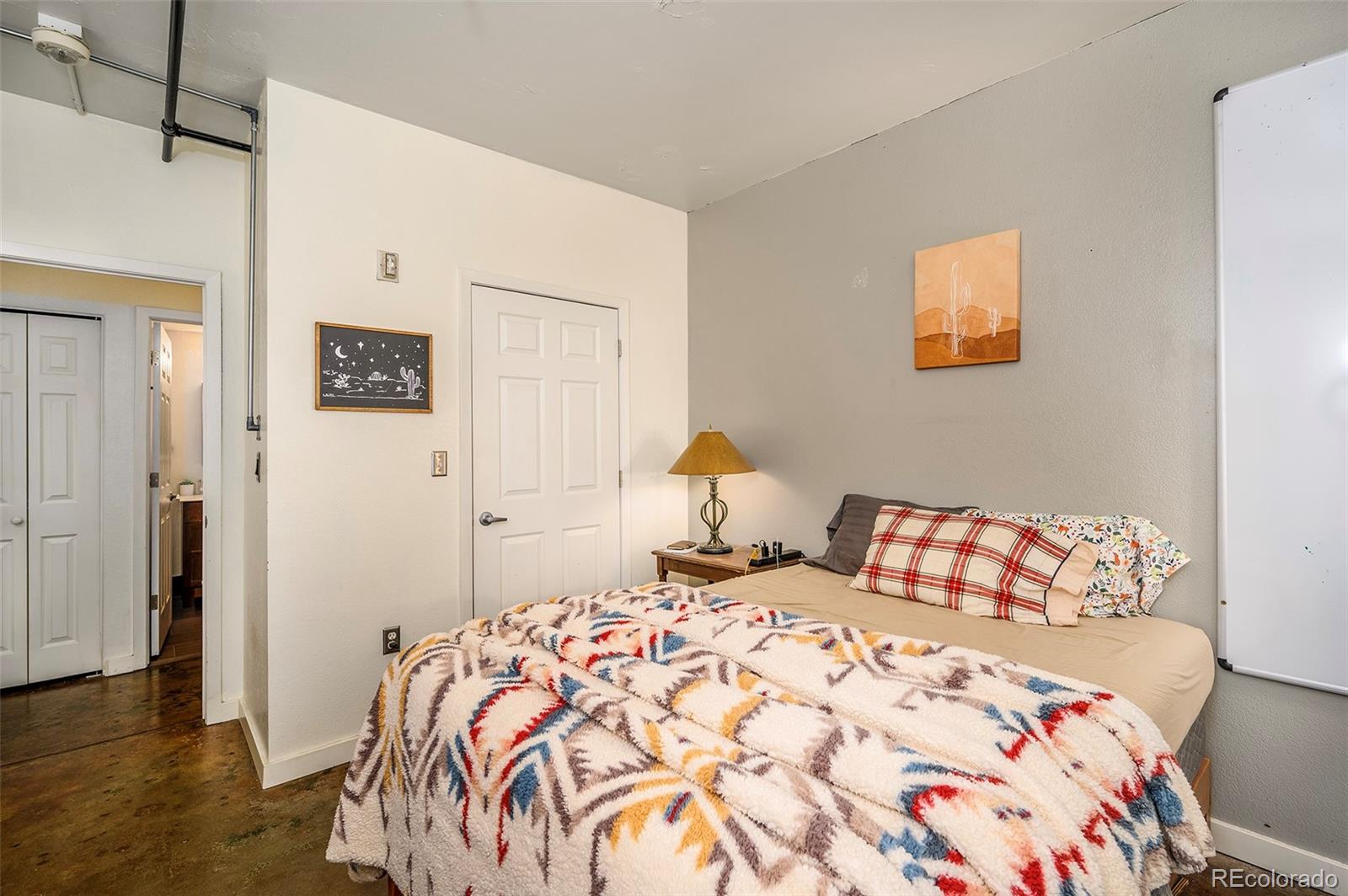 444 17th Street, Unit 904 Denver, CO 80202 - Photo 12 of 18 a bedroom with a bed and wooden floor