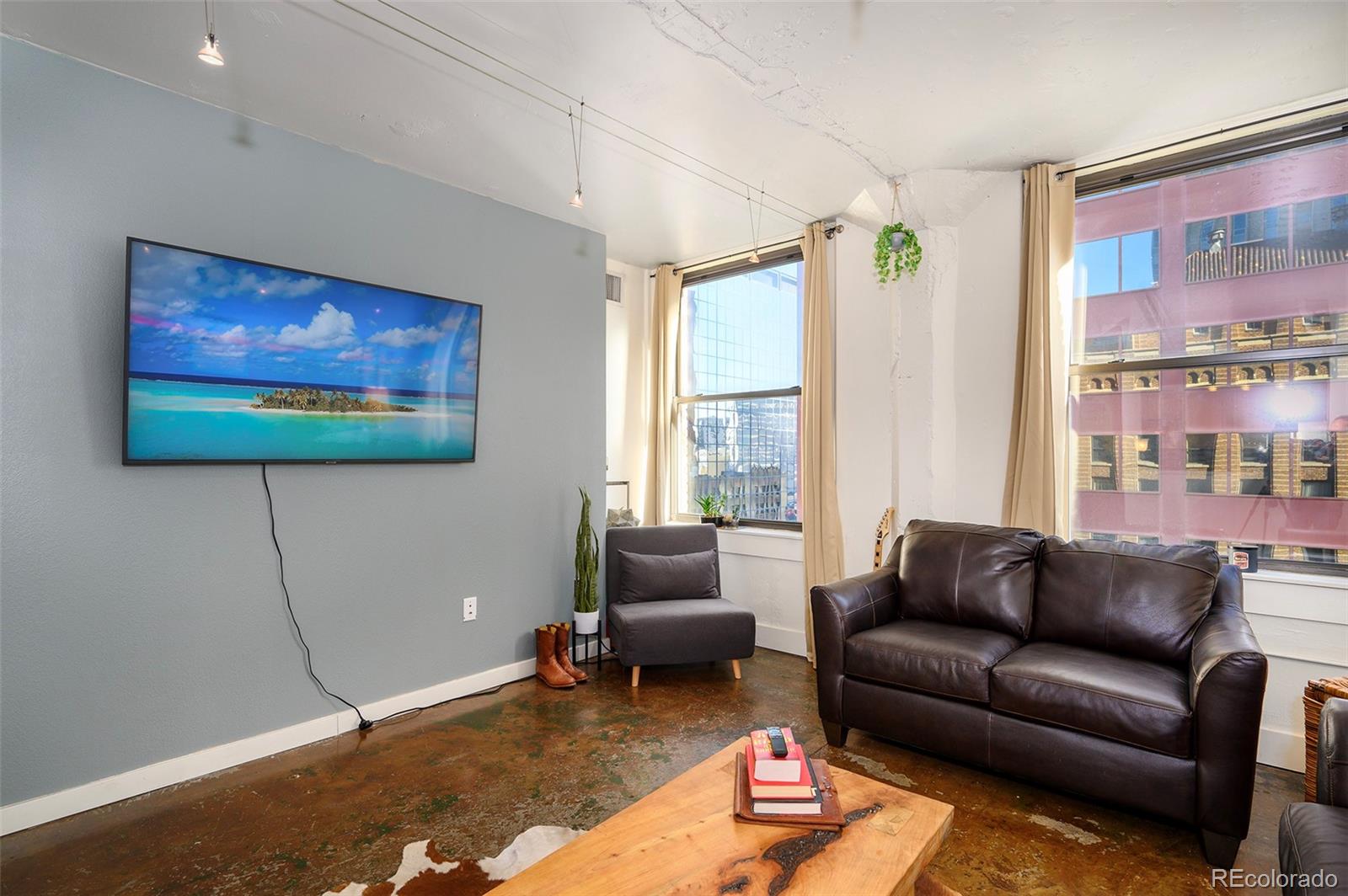 444 17th Street, Unit 904 Denver, CO 80202 - Photo 6 of 18 a living room with furniture a flat screen tv and a window
