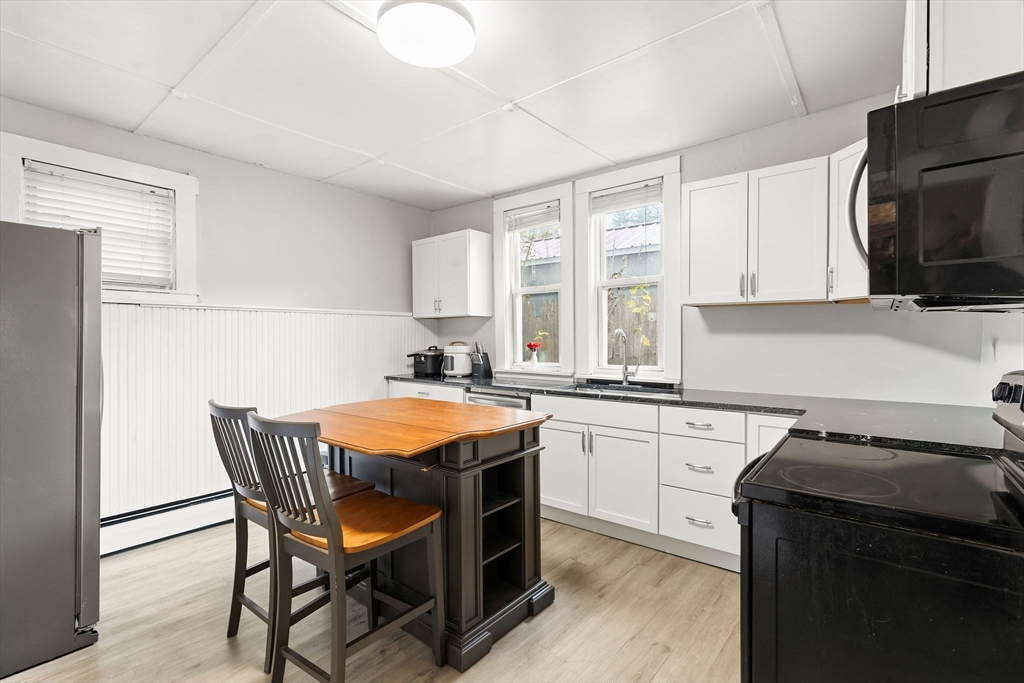 23 Fletcher Place Athol, MA 01331 - Photo 5 of 29 a kitchen with stainless steel appliances granite countertop a table chairs sink refrigerator and microwave