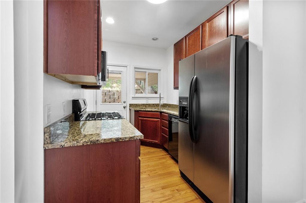 324 Merrimac Street Pittsburgh, PA 15211 - Photo 15 of 37 a kitchen with kitchen island granite countertop wooden cabinets a refrigerator and a sink