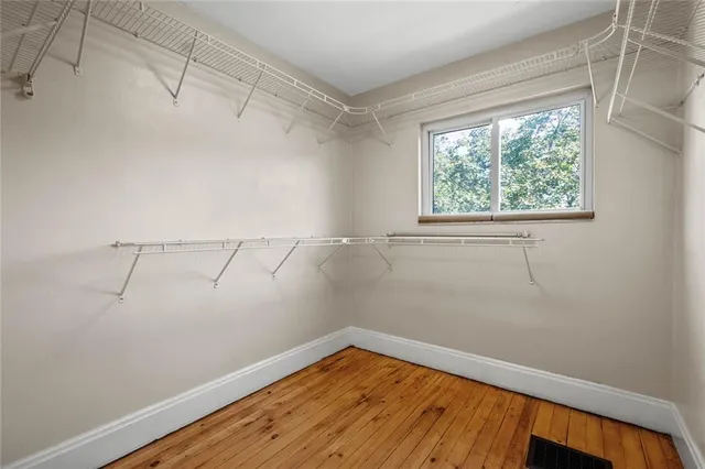 a view of a room with wooden floor and small window