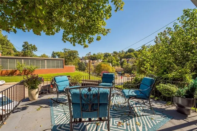 an outdoor sitting area with furniture and lake view