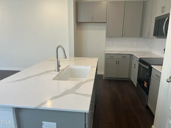 a kitchen with a sink and a stove top oven