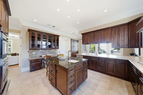 a kitchen with stainless steel appliances kitchen island granite countertop a sink and cabinets