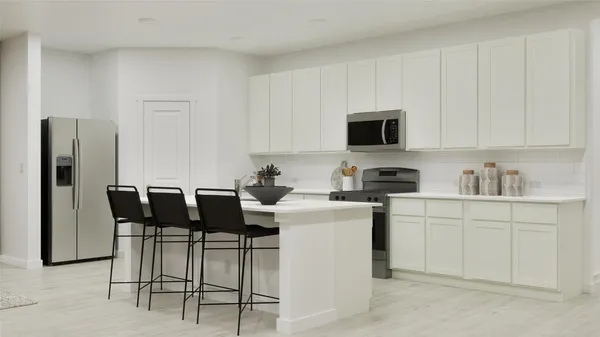 a kitchen with stainless steel appliances kitchen island granite countertop a refrigerator and a stove top oven