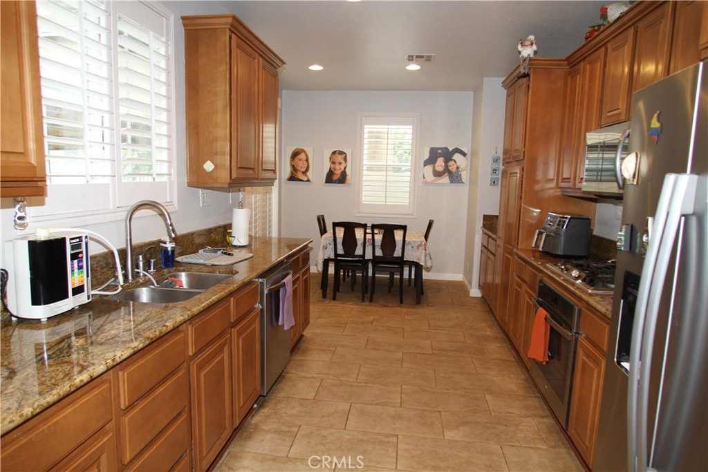 2660 West Madison Circle Anaheim, CA 92801 - Photo 17 of 52 a large kitchen with stainless steel appliances granite countertop a sink counter space and a window