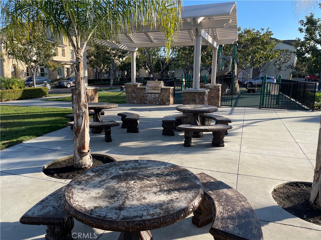 2660 West Madison Circle Anaheim, CA 92801 - Photo 49 of 52 a view of a patio with table and chairs potted plants and palm trees
