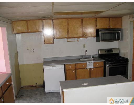 21 Piedmont Road Edison, NJ 08817 - Photo 2 of 6 a kitchen with stainless steel appliances kitchen island granite countertop a stove a sink and a microwave