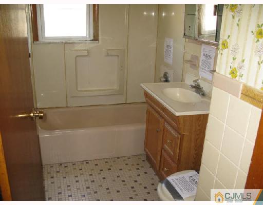 21 Piedmont Road Edison, NJ 08817 - Photo 5 of 6 a bathroom with a sink a mirror and a bathtub