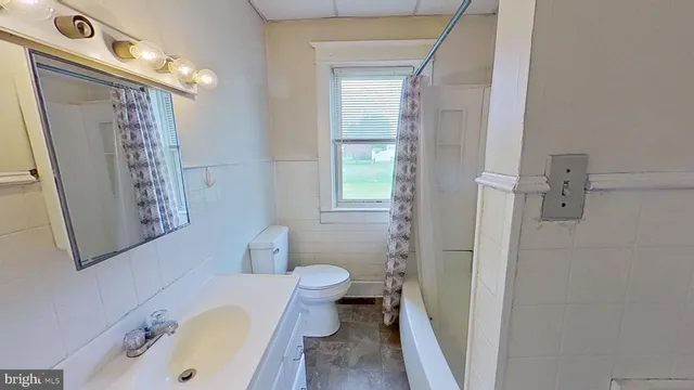 a bathroom with a sink a toilet and shower curtain