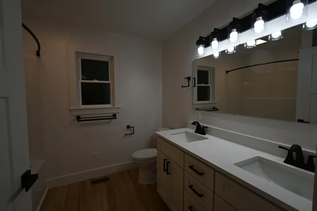 a bathroom with a sink a toilet and mirror