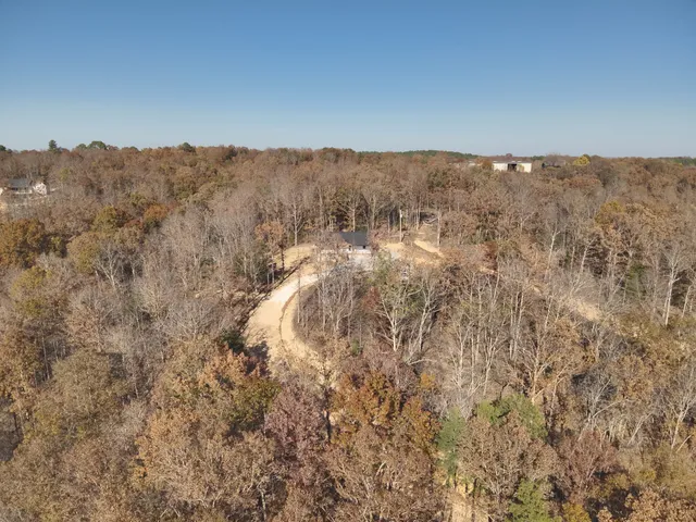 a view of a dry yard with wooden fence