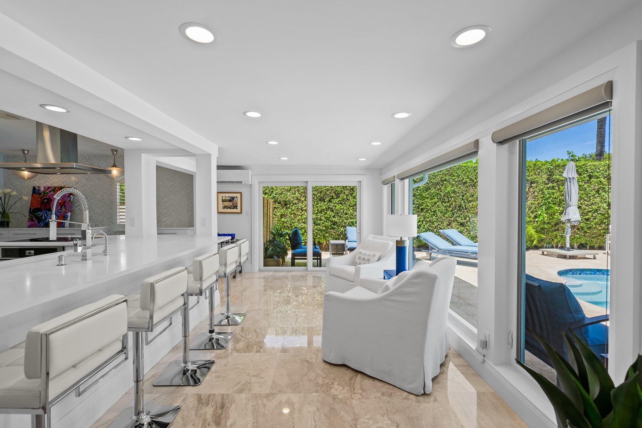 1090 Cypress Way Boca Raton, FL 33486 - Photo 6 of 40 a living room with furniture large windows a sink and a fireplace