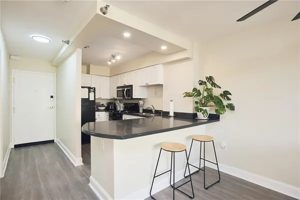 a kitchen with stainless steel appliances granite countertop a sink a refrigerator and a counter top space