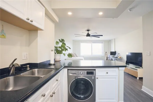 a kitchen with a sink and a stove top oven with wooden floor