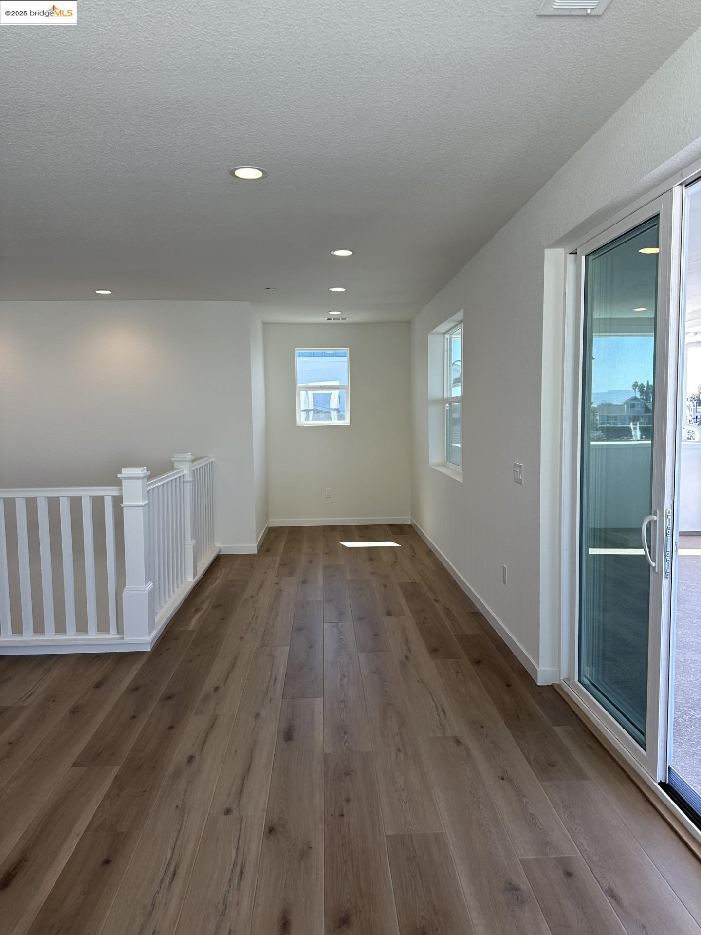 667 Point Place Bethel Island, CA 94511 - Photo 17 of 27 an empty room with wooden floor and windows