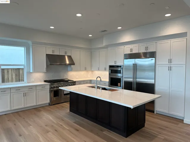 a kitchen with a sink a stove a refrigerator and cabinets