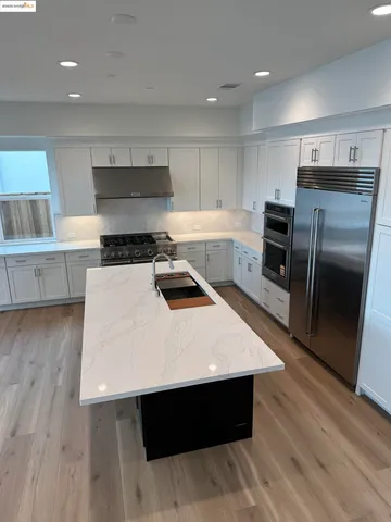 a kitchen with white cabinets and black appliances