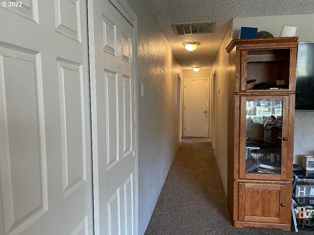 449 East 4th Avenue Riddle, OR 97469 - Photo 8 of 17 a view of a hallway with wooden floor and a living room